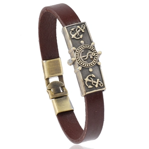 Vintage nautical leather bracelet featuring bronze anchor and rudder metal plaques