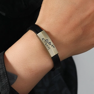 Minimalist black leather bracelet featuring a vintage bronze plate with heart arrow engraving