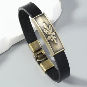 Macro detail of men's leather bracelet with vintage bronze maple leaf plaque