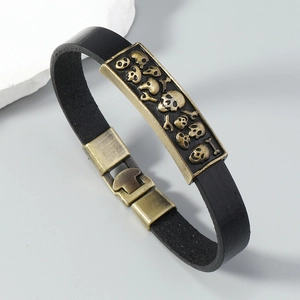Detail of vintage leather bracelet featuring bronze skull plate and punk gothic clasp