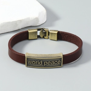 Detail of brown leather bracelet with world peace engraving on vintage bronze plaque
