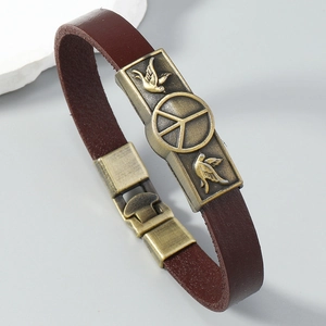 Detail of vintage cowhide bracelet featuring a bronze peace sign metal plate and snap buckle