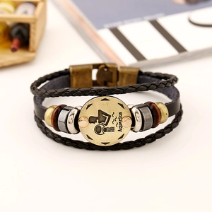 Macro shot of Aquarius sign on multi-layer braided leather bracelet with beads