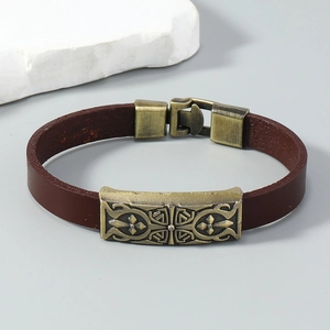 Detail of vintage brown leather bracelet with an antique bronze cross pattern buckle