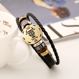 Vue macro du bracelet en cuir Taureau avec charme zodiaque en bronze et liens tressés