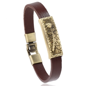 Bracelet vintage en cuir marron avec plaque en bronze à fleurs roses sur fond blanc