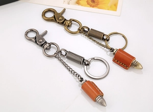 Detail of vintage leather keychain with bronze bullet pendant and metal lobster clasp