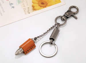 Macro shot of punk style bullet pendant with brown leather wrap and metal lobster clasp