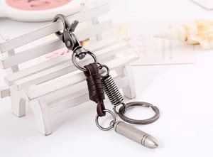 Detailed view of vintage brown leather keychain with bullet pendant and antique silver clasp