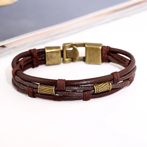 Bracciale multistrato vintage in pelle marrone scuro con chiusura in bronzo su sfondo bianco