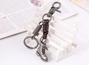 Detail of vintage leather braided keychain with an alloy work boot pendant on a mini bench