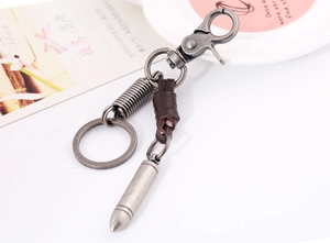 Detail of vintage leather keychain with lobster clasp and antique silver bullet pendant
