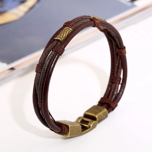 Bracciale multistrato in pelle intrecciata retrò con inserti in metallo bronzo su bianco