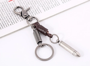 Macro shot of vintage silver metal keychain with dark brown leather and bullet pendant