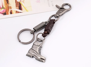 Detail of vintage bronze shoe pendant on woven leather keychain with lobster clasp