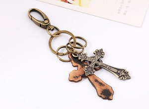Vue détaillée du pendentif croix vintage avec crochets en bronze et textures en cuir