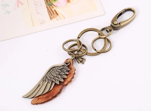 Detailed macro view of vintage bronze wing pendant and premium brown leather keychain