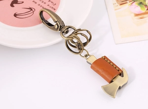 Close-up of bronze hammer keychain with brown leather cover and multi-ring detail