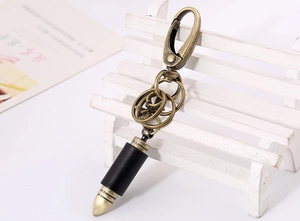 Detailed view of vintage bronze bullet pendant with black leather wrap on a keychain