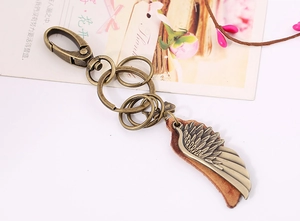 Detail of vintage bronze wing pendant on leather keyring with floral gift card