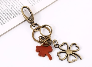 Detail of vintage bronze four-leaf clover keychain with leather charm and metal rings