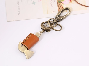 Detail of vintage bronze hammer keychain with brown leather cover and metal rings