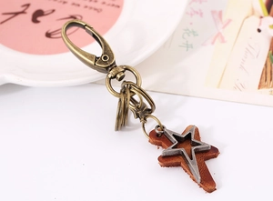 Detail of vintage bronze lobster clasp and leather star pendant keychain for bags