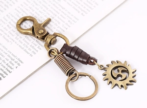 Macro view of vintage bronze alloy keychain with leather trim on open book pages