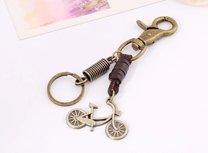 Detail view of retro alloy bicycle pendant with brown leather strap on metal keychain