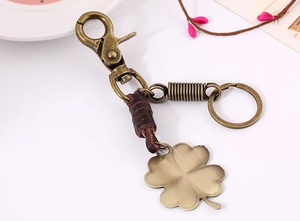 Detail of vintage bronze keychain with dark brown leather wrap and lucky clover pendant