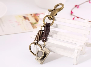 Detail of vintage bronze camera keychain with dark brown leather and horseshoe clasp