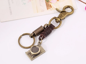 Detail of vintage bronze camera keychain with brown leather wrap and lobster clasp
