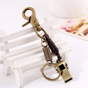 Vintage leather keychain with metal whistle and spring pendant on a white chair display