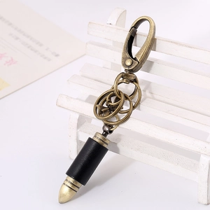 Vintage bullet keychain in genuine leather with antique alloy clasp on a mini bench