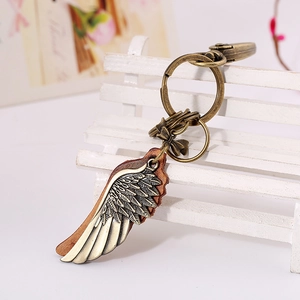 Retro bronze wing leather keychain with swivel lobster clasp on mini white bench