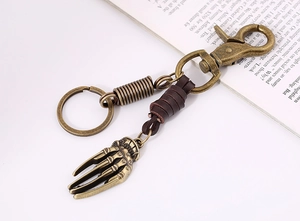 Detail eines Vintage-Leder-Schlüsselanhängers mit Skeletthand-Anhänger aus Bronze