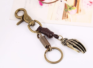Detail eines Vintage Punk Schlüsselanhängers mit Bronze-Hand und Lederverzierung