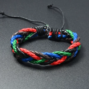 Détail d'un bracelet en cuir tressé coloré avec fermoir à nœud réglable sur fond sombre