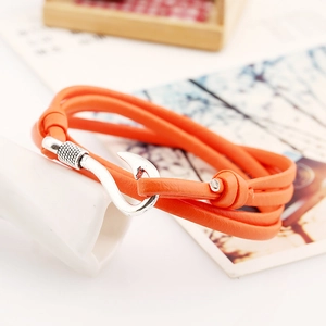 Detail eines orangefarbenen nautischen Lederarmbands mit silbernem Fischhakenverschluss