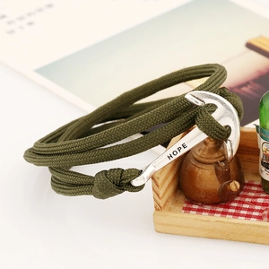 Macro shot of olive green nylon rope bracelet with silver anchor clasp engraved with HOPE