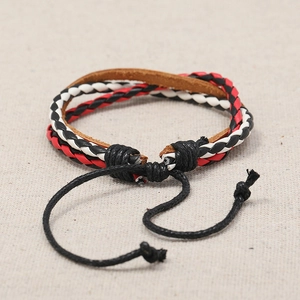 Vintage multi-layer braided leather bracelet with adjustable cords on beige fabric
