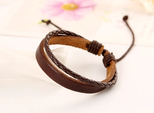 Dettaglio del bracciale multistrato in pelle marrone scuro con cordino intrecciato e nodo