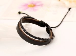 Dettaglio del bracciale multistrato in pelle intrecciata nera con cordino regolabile