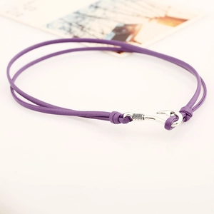 Detail eines lila Lederarmbands mit doppellagigem Seil und silbernem Fischhaken
