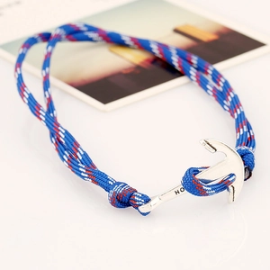 Macro shot of silver anchor clasp with HO engraving on navy style braided rope bracelet