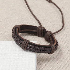 Handmade multilayer dark brown leather braided bracelet with adjustable cord on linen