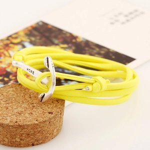 Gros plan d'un bracelet tressé jaune multicouche avec fermoir ancre argenté gravé HOPE