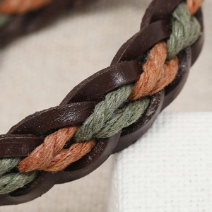 Macro shot of handmade braided cowhide leather bracelet with vintage textured fiber cords
