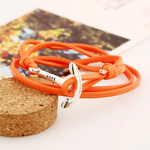 Détail du bracelet en cuir PU tressé orange avec ancre argentée gravée du mot HOPE