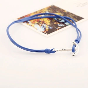 Gros plan d'un bracelet en cuir tressé bleu avec pendentif ancre argenté gravé du mot HOPE